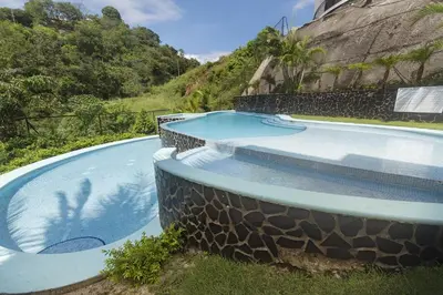 a swimming pool with a rock wall next to a resort at Playa Flamingo, Stunning Sunset View Condominium Flamingo Towers 17 in Playa Flamingo