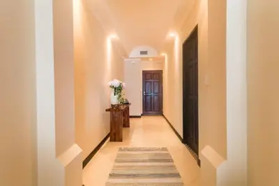 a hallway with white walls and a door and a rug at Playa Flamingo, Stunning Sunset View Condominium Flamingo Towers 17 in Playa Flamingo