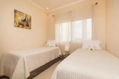 two beds in a room with a window at Playa Flamingo, Stunning Sunset View Condominium Flamingo Towers 17 in Playa Flamingo
