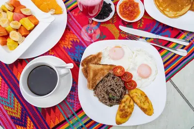 a breakfast plate with eggs and toast and a cup of coffee at Cabañas Valle Campanas - Monteverde, Costa Rica in Monteverde Costa Rica
