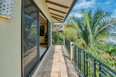 a balcony with a view of palm trees at Canto del Mar #20 in Dominical