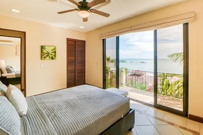 a bedroom with a bed and a view of the ocean at Canto del Mar #20 in Dominical