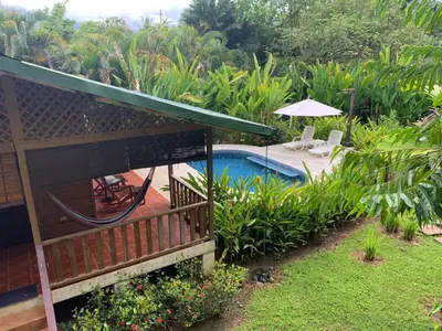 a backyard with a swimming pool and a house at Ocean Melody 2 in Uvita