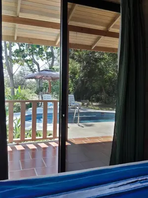 a view of a pool from a patio with an umbrella at Ocean Melody 2 in Uvita