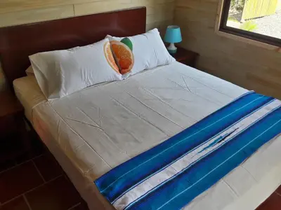 a bed with a pillow with a fruit on it at Ocean Melody 2 in Uvita