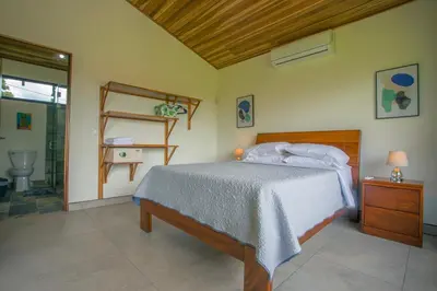a bedroom with a bed with a wooden head board at La Finca Lodge in Fortuna