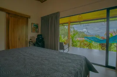 a bedroom with a bed and a large window at La Finca Lodge in Fortuna