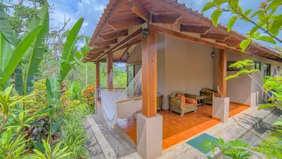 an outside view of a house with a hammock at La Finca Lodge in Fortuna