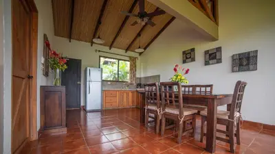 a kitchen with a table and chairs and a refrigerator at La Finca Lodge in Fortuna