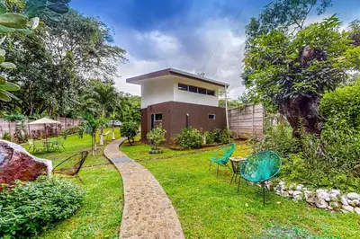 a garden with chairs and a house in the background at Nueva Villa Paraíso Four Villas in Lagunillas