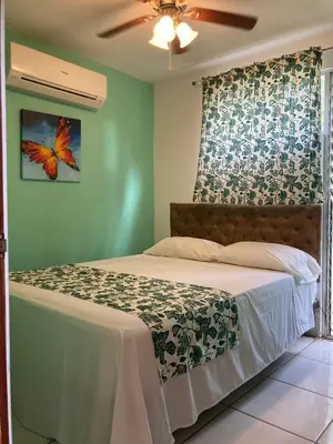 a bedroom with a bed with a butterfly on the wall at Nueva Villa Paraíso Four Villas in Lagunillas