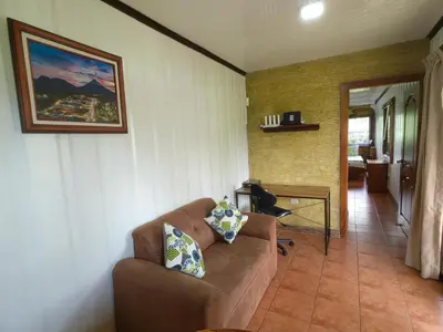 a living room with a couch and a picture on the wall at Arenal Homes La Fortuna in Fortuna