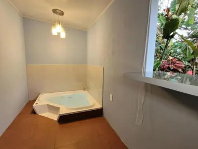 a bath tub in a bathroom with a window at Arenal Homes La Fortuna in Fortuna