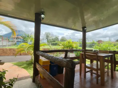 a screened in porch with a table and a chair at Arenal Homes La Fortuna in Fortuna