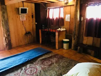 a bedroom with a bed and a table in a room at Hotel Chalets Los Volcanes in Alajuela City