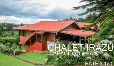 a house with a red roof and a yard at Hotel Chalets Los Volcanes in Alajuela City
