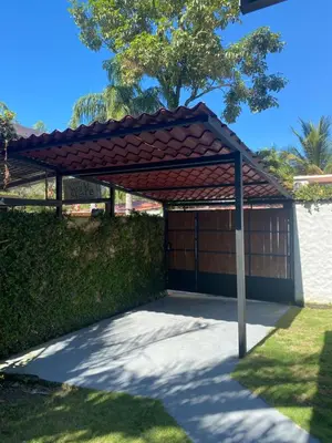 a wooden garage with a red roof at Casa Piscina in Santa Teresa Beach