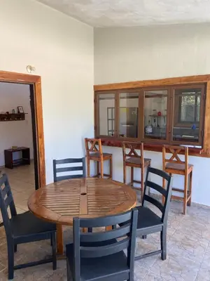 a dining room with a wooden table and chairs at Casa Piscina in Santa Teresa Beach