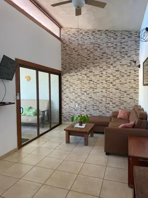 a living room with a couch and a brick wall at Casa Piscina in Santa Teresa Beach