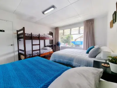 a bedroom with two beds and a window at Casa Jardin del Mango in San José
