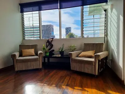 two chairs and a table in a room with windows at Casa Jardin del Mango in San José