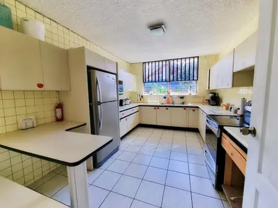 a kitchen with a refrigerator and a table in it at Casa Jardin del Mango in San José