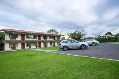 two cars parked in a parking lot in front of a building at Condo's Vista Al Volcan in Fortuna