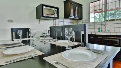 a dining room table with plates and wine glasses at Condo's Vista Al Volcan in Fortuna