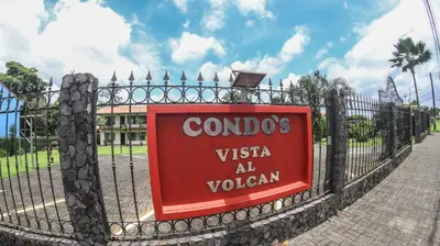 a sign on a fence in front of a building at Condo's Vista Al Volcan in Fortuna