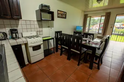 a kitchen with a stove and a table with chairs at Condo's Vista Al Volcan in Fortuna