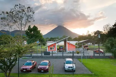a group of cars parked in a parking lot with a mountain in the background at Condo's Vista Al Volcan in Fortuna