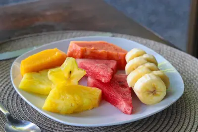a white plate of fruit on a table at Hotel Flor de Bromelia in Monteverde Costa Rica