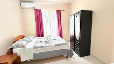 a bedroom with a bed and a dresser and a window at Yellow House in Quepos