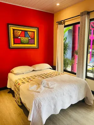 a bedroom with a bed with a red wall at Millenium Manuel Antonio Park and beach in Manuel Antonio