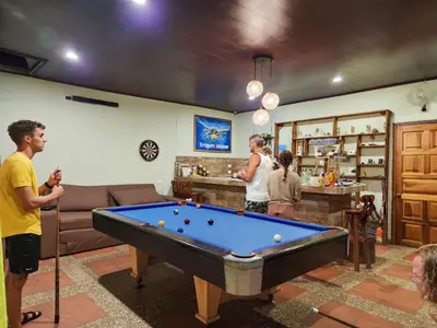 a group of people in a living room with a pool table at Hostel Tortuguero 7BackPackers in Tortuguero