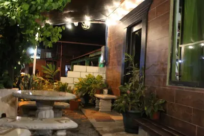 a patio with tables and potted plants next to a building at Hostel Tortuguero 7BackPackers in Tortuguero