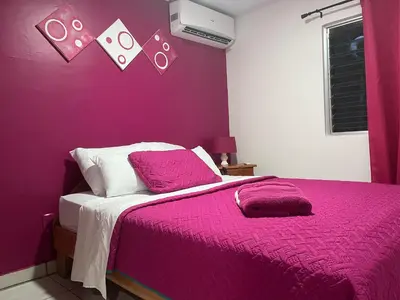 a purple bedroom with a bed with a pink blanket at Villas Majolana in Herradura