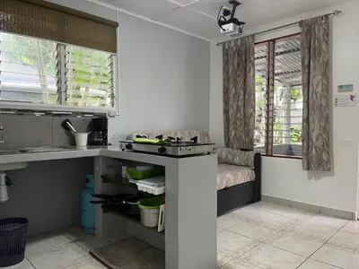 a kitchen with a sink and a couch in a room at Villas Majolana in Herradura