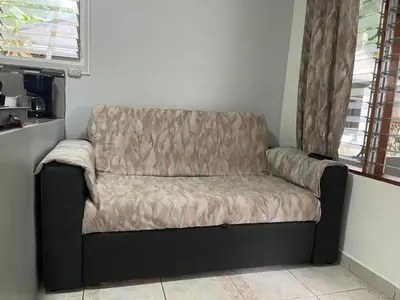 a couch sitting next to a window in a room at Villas Majolana in Herradura