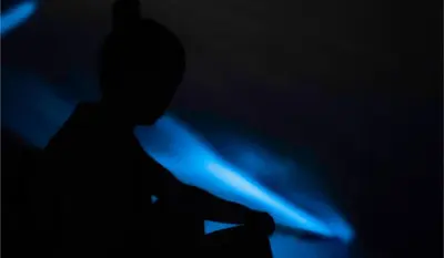 a silhouette of a person sitting in the dark at Isla Chiquita Glamping Hotel in Puntarenas