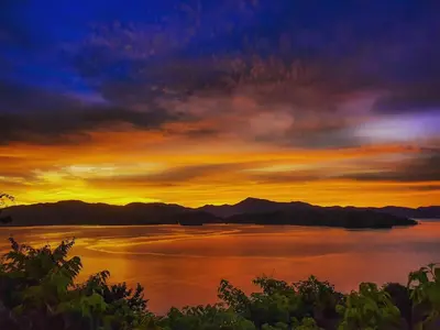 a sunset over a large body of water at Isla Chiquita Glamping Hotel in Puntarenas