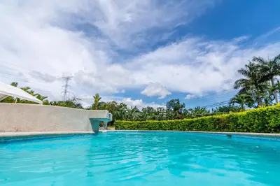 a swimming pool in a villa with a blue sky at Hotel Pacuare in Siquirres