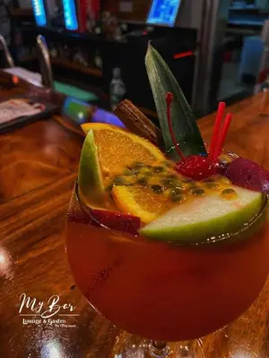 a drink with fruit on top of a wooden table at Hotel Pacuare in Siquirres