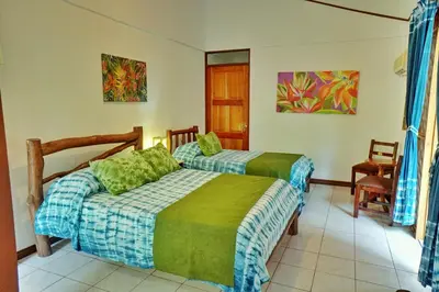 a bedroom with two beds in a room at La Quinta Sarapiqui Lodge in Sarapiquí