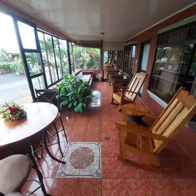 a room with wooden chairs and tables and windows at Hotel Torre Fuerte in Venecia