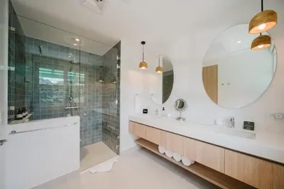 a bathroom with a shower and a sink and mirror at Las Villas Marina Pez Vela in Quepos