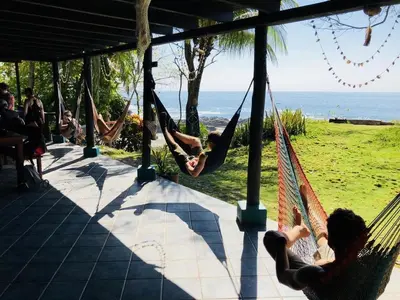 a group of people chilling in hammocks on the beach at Luminosa Montezuma Hostel in Montezuma
