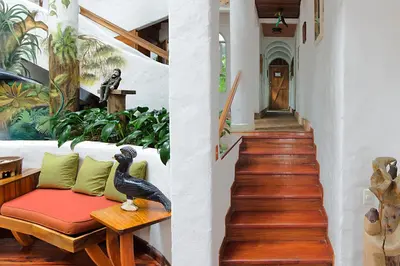 a living room with a couch and a stairway at Finca Rosa Blanca Coffee Farm and Inn in Heredia