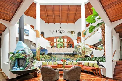 a living room with a couch and a fireplace at Finca Rosa Blanca Coffee Farm and Inn in Heredia