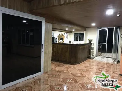 a lobby with a large glass door and a counter at Hotel Palenque Tarrazu in San Marcos